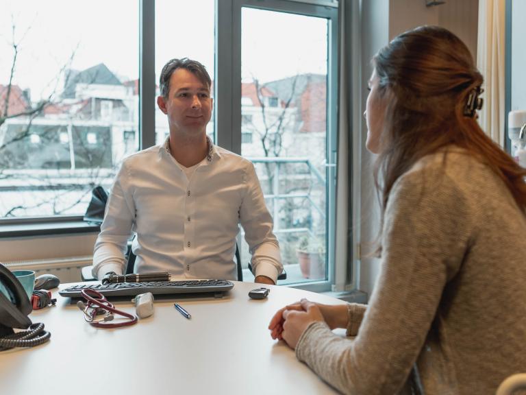 Huisarts in spreekkamer met patiënt