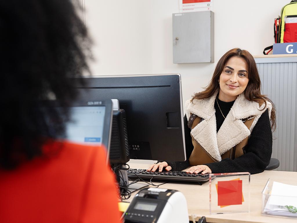 Doktersassistent achter pc in gesprek met collega